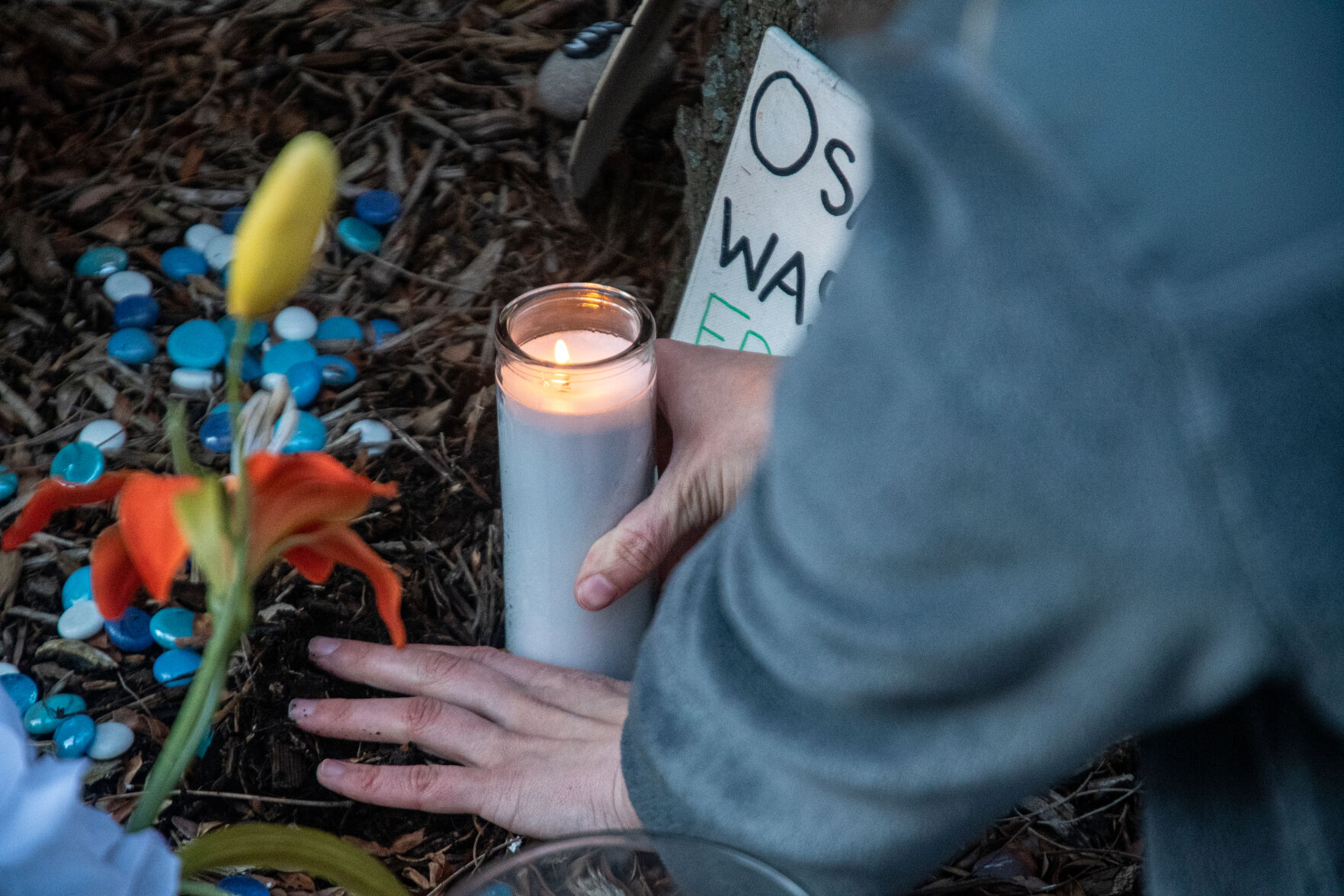 Student 3/20 Coalition member plants candle during 'Reflect and Respect' event